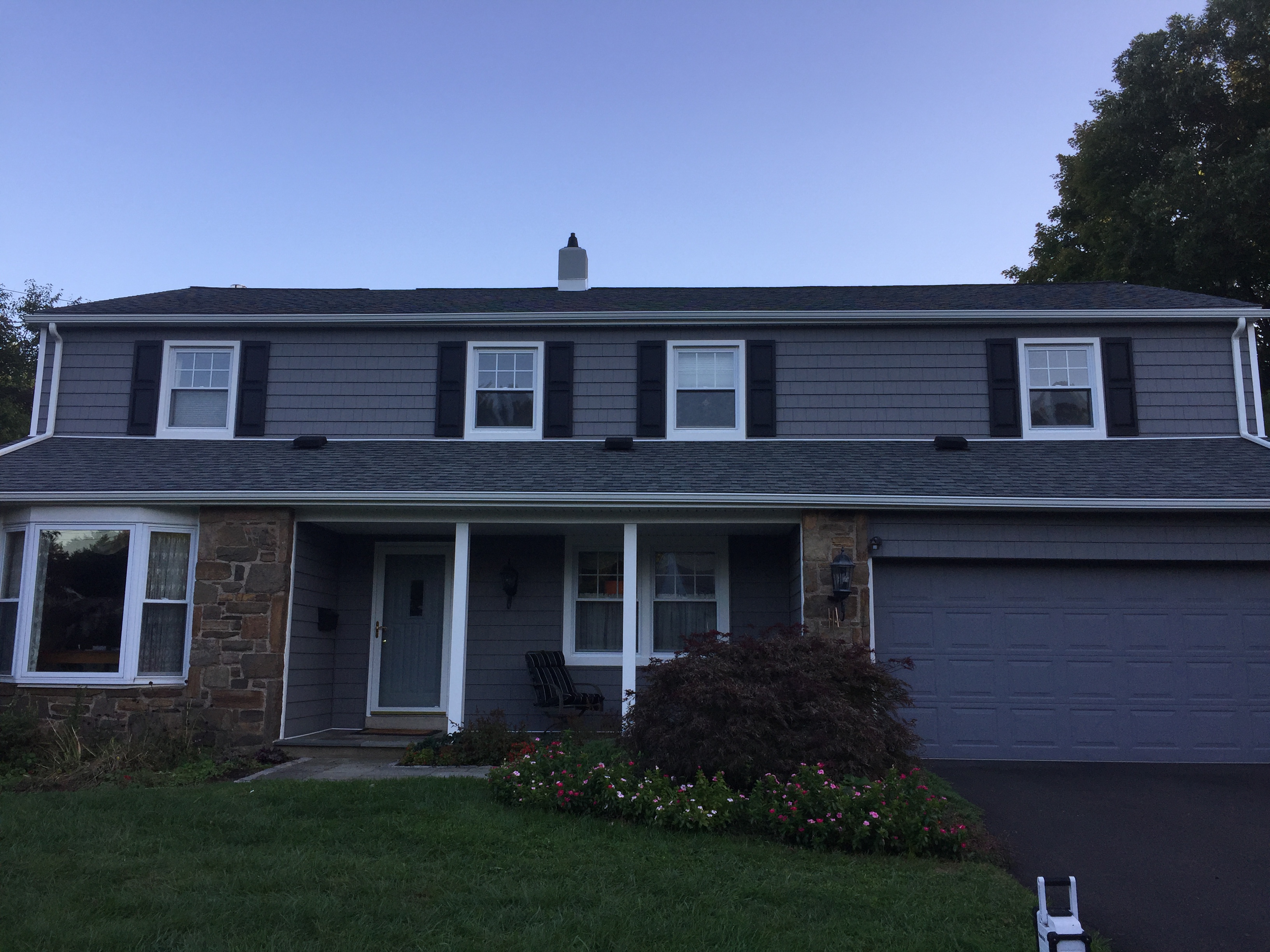 Residential home with roofing, siding and a covered front entry